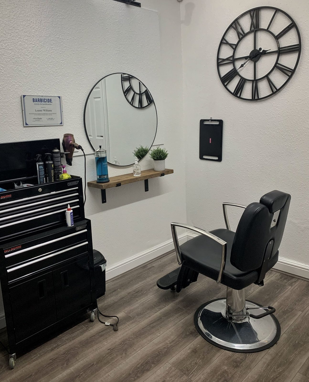 Barber station with circular mirror, Barbicide jar and large wall clock